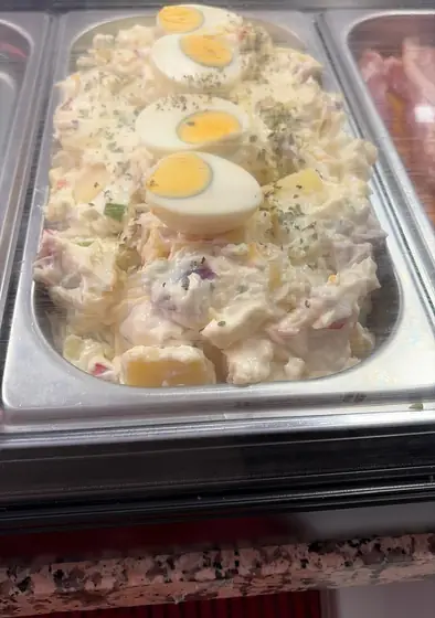 Ensaladilla con huevo duro en una bandeja de la vitrina