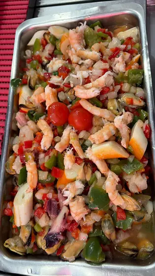 Salpicón con gambas, pimientos y cebolla en una bandeja de la vitrina